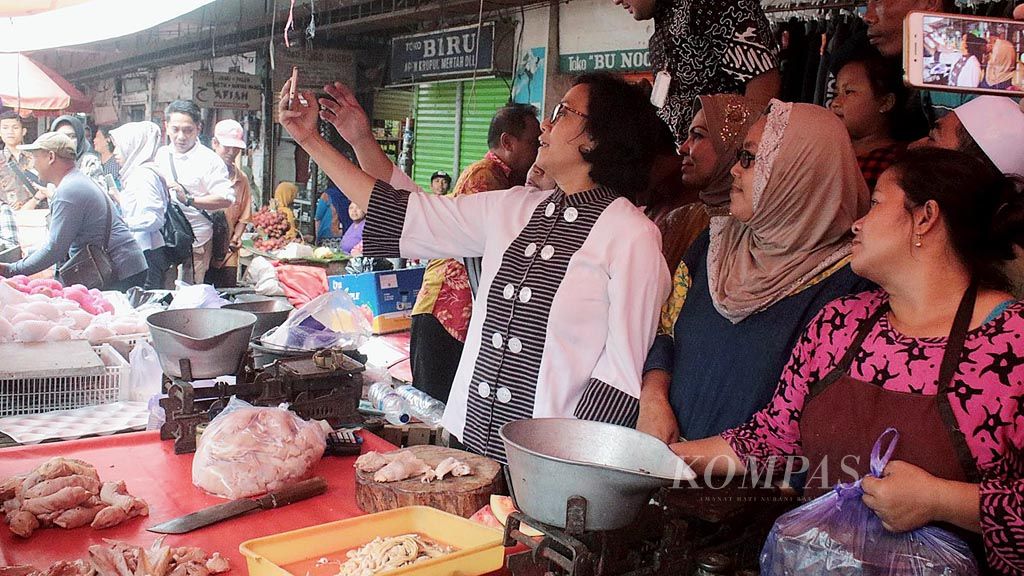  Menteri Keuangan Sri Mulyani Indrawati berswafoto dengan pedagang di Pasar Besar Kota Malang, Jawa Timur, Kamis (4/1). Sri Mulyani meninjau pemberian kredit ultramikro  untuk para pengusaha kecil yang tidak bisa mengakses modal dari perbankan.