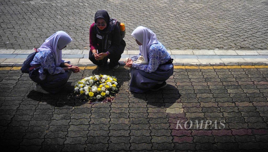 Beberapa pelajar dan guru mereka yang mengikuti Napak Tilas Tragedi Mei 1998 berdoa di depan titik salah satu mahasiswa Universitas Trisakti meninggal ditembak tentara dan menjadi salah satu korban Tragedi 1998 di depan Museum Trisakti, Kampus Universitas Trisakti, Jakarta, Minggu (12/5/2024).