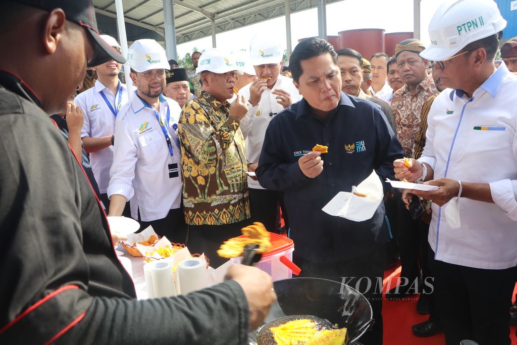 Menteri Badan Usaha Milik Negara Erick Thohir (kedua dari kanan) mencicipi pisang goreng yang dimasak dengan minyak makan merah di pabrik minyak makan merah Pagar Merbau, Kabupaten Deli Serdang, Sumatera Utara, Jumat (6/1/2023). 