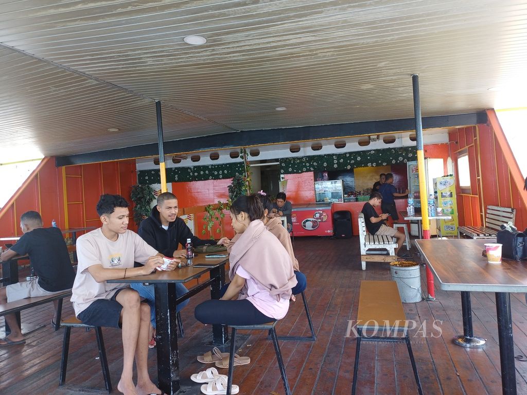 Beberapa penumpang menikmati minuman dan makanan ringan di kafe KM Umsini, dek tujuh, Jumat (21/7/2023). 