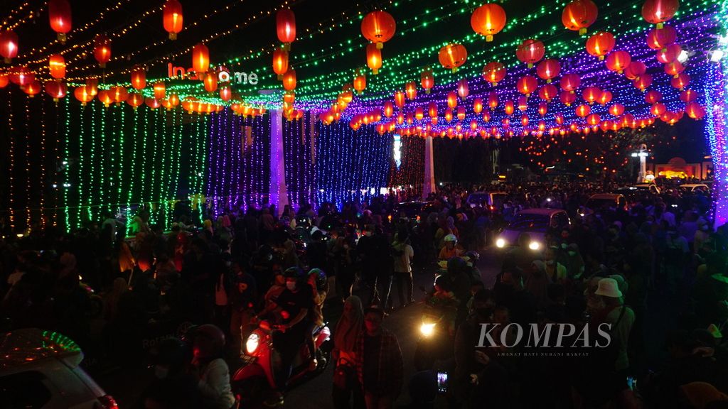 Masyarakat berbondong-bondong mendatangi lampion perayaan Imlek yang dipasang di  kawasan Pasar Gede, Kota Surakarta, Jawa Tengah, Minggu (30/1/2022). 