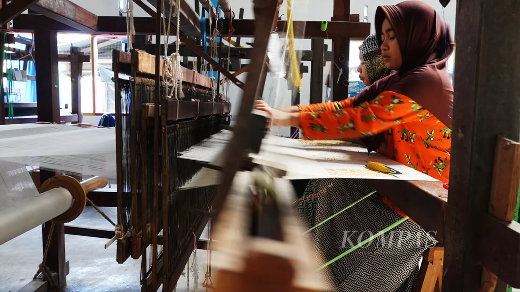 Pekerja menyelesaikan pengerjaan kain tenun Siak di tempat pembuatan tenun Mekar Permai di Jalan Indragiri, Kota Siak Sri Inderapura, Kabupaten Siak, Riau, Jumat (27/12/2019).