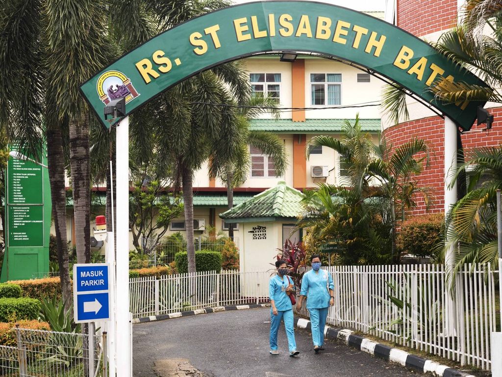 Dua tenaga kesehatan melewati gerbang Rumah Sakit Elisabeth, Lubuk Baja, Batam, Kepulauan Riau, Selasa (1/9/2020). 