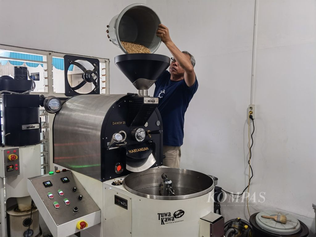 Direktur Tuwa Kawa Coffee and Roastery Mujiburrahman (50), memasukkan biji kopi ke dalam mesin roasting di kedainya di Kawasan Jalan Gunung Kerinci, Selaparang, Kota Mataram, Nusa Tenggara Barat, Selasa (15/11/2022) lalu. 
