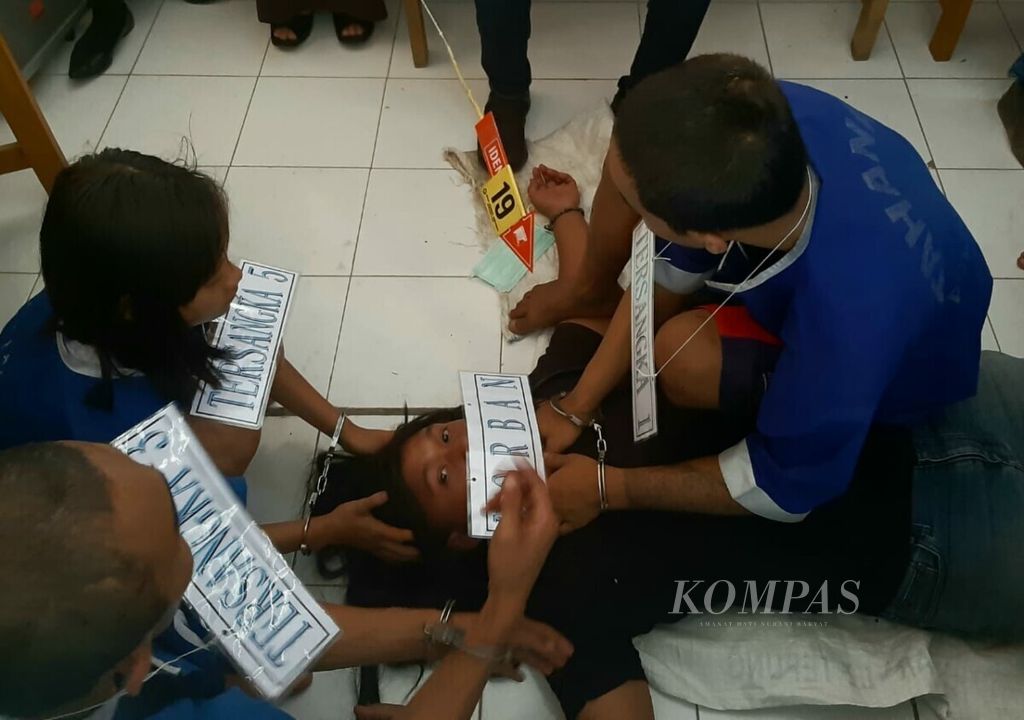 Seorang tersangka tengah memperagakan adegan pembunuhan yang dilakukannya kepada NH. Korban NH dibunuh dengan cara dicekik menggunakan tali tas miliknya.