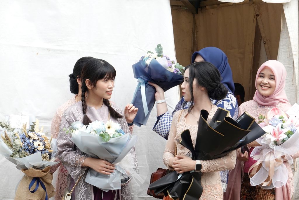 Keluarga membawa bunga dan menanti para calon perwira remaja yang masih menghadiri Upacara Prasetya Perwira (Praspa) TNI-Polri Tahun 2023 yang digelar di halaman Istana Merdeka, Jakarta, pada Rabu (26/7/2023).