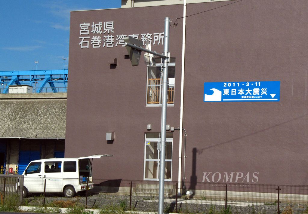 Salah satu dinding bangunan di pusat kota Ishinomaki, Prefektur Miyagi, Jepang, ditempeli tanda yang menunjukkan batas tertinggi air saat tsunami melanda, 11 Maret 2011 lalu. Gambar diambil pada Kamis (13/9/2012).