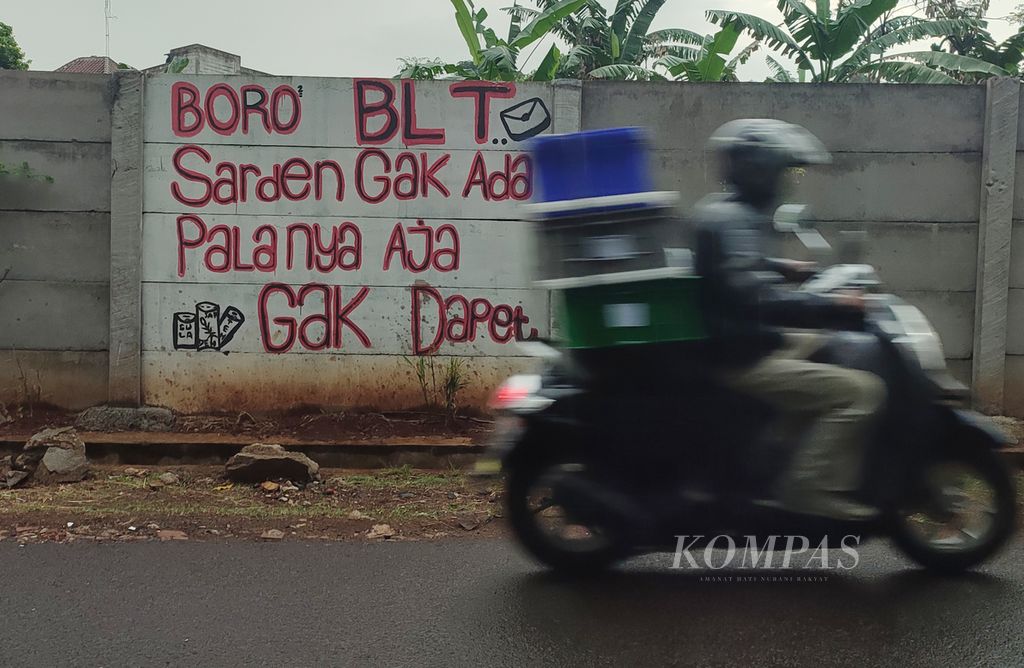 Sentilan terkait penyaluran bantuan langsung tunai (BLT) yang tidak merata tertulis di sebuah tembok pagar di kawasan Pondok Cabe, Tangerang Selatan, Banten, Selasa (5/4/2022). 
