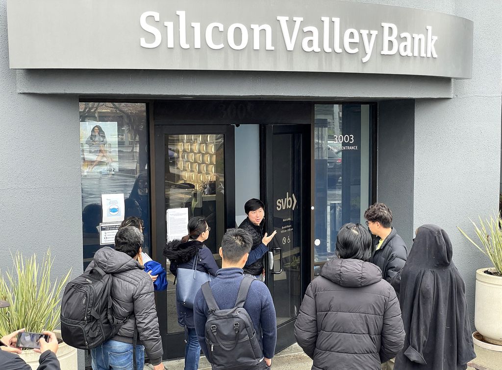 Seorang pekerja berbincang dengan orang-orang yang berada di depan kantor Silicon Valley Bank (SVB) di Santa Clara, California, Amerika Serikat, yang ditutup pada 10 Maret 2023. 