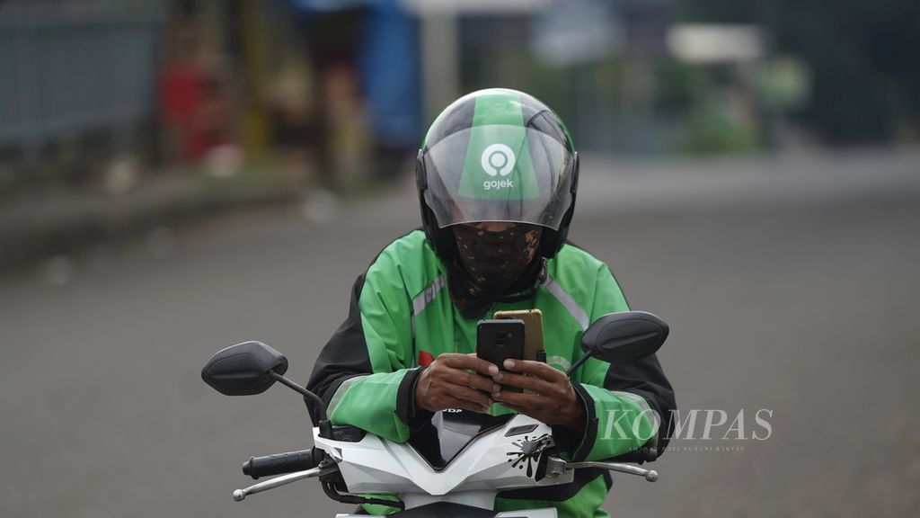 Ojek daring membuka aplikasi, menunggu orderan di Bintara, Kota Bekasi, Jawa Barat, Kamis (20/4/2023). 