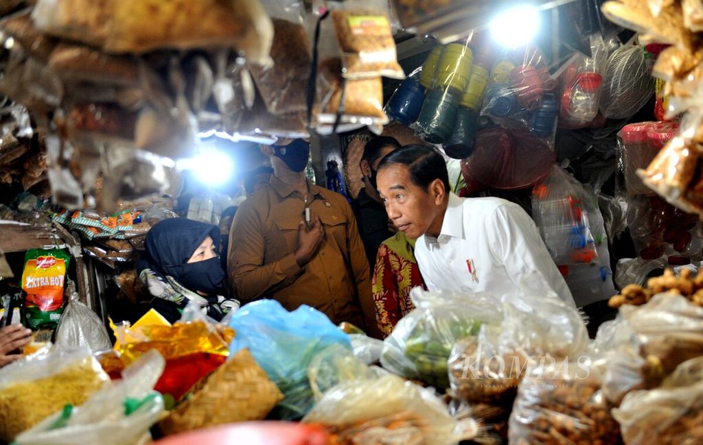 Dengan teliti, Presiden Joko Widodo mendengarkan penjelasan salah satu pedagang di Pasar Wonokromo, Surabaya, Jawa Timur, Sabtu (18/2/2023). Presiden melakukan kunjungan kerja di Surabaya dengan mendatangi Pasar Wonokromo. 
