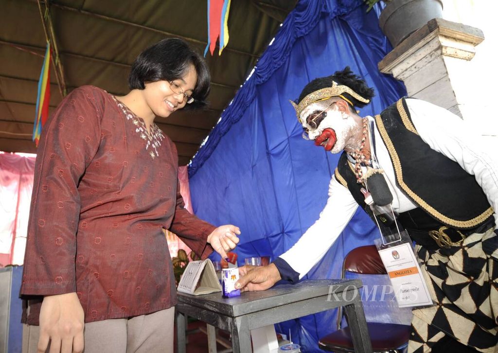 Dengan menggunakan kostum punakawan, anggota KPPS TPS 01 Purwoyoso, Kecamatan Ngaliyan, Kota Semarang, Jawa Tengah, membantu warga yang baru menggunakan hak suaranya, 8 Juli 2009. 