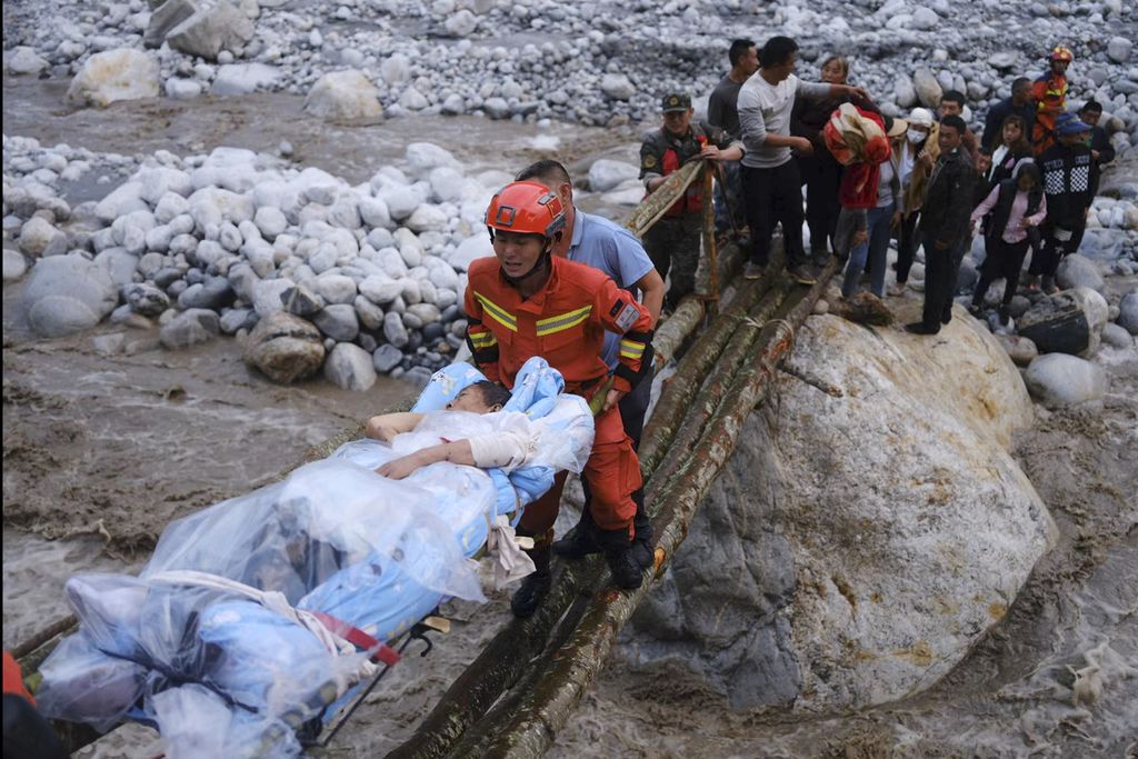 Dalam foto yang dirilis Kantor Berita Xinhua, petugas penyelamat memindahkan korban selamat melintasi sungai pascagempa bumi di Kabupaten Luding, Provinsi Sichuan, China, Senin (5/9/2022). 