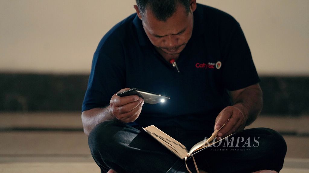 Umat Islam membaca Al Quran dengan bantuan penerangan lampu telepon genggam di Masjid Izzatul Islam, Grand Wisata, Kecamatan Tambun Selatan, Kabupaten Bekasi, Jawa Barat, Kamis (7/4/2022). 