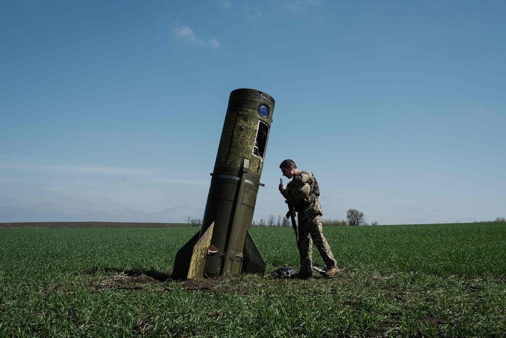 Seorang tentara Ukraina memeriksa sebuah pendorong rudal balistik Rusia yang jatuh di sebuah ladang di Bohodarove, Ukraina timur, Senin (25/4/2022). 