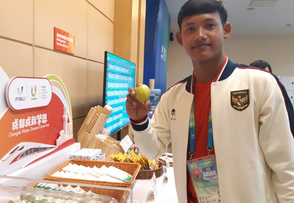 Atlet tenis Indonesia, Arian Rangga Desvianto mencoba makanan di ruang tunggu atlet di Sichuan International Tennis Center, Chengdu, China, Rabu (26/7/2023) sore. Di ruang tunggu ini, tersedia sejumlah buah-buahan, minuman, dan camilan. Selain itu, ruangan ini juga memiliki meja biliar.