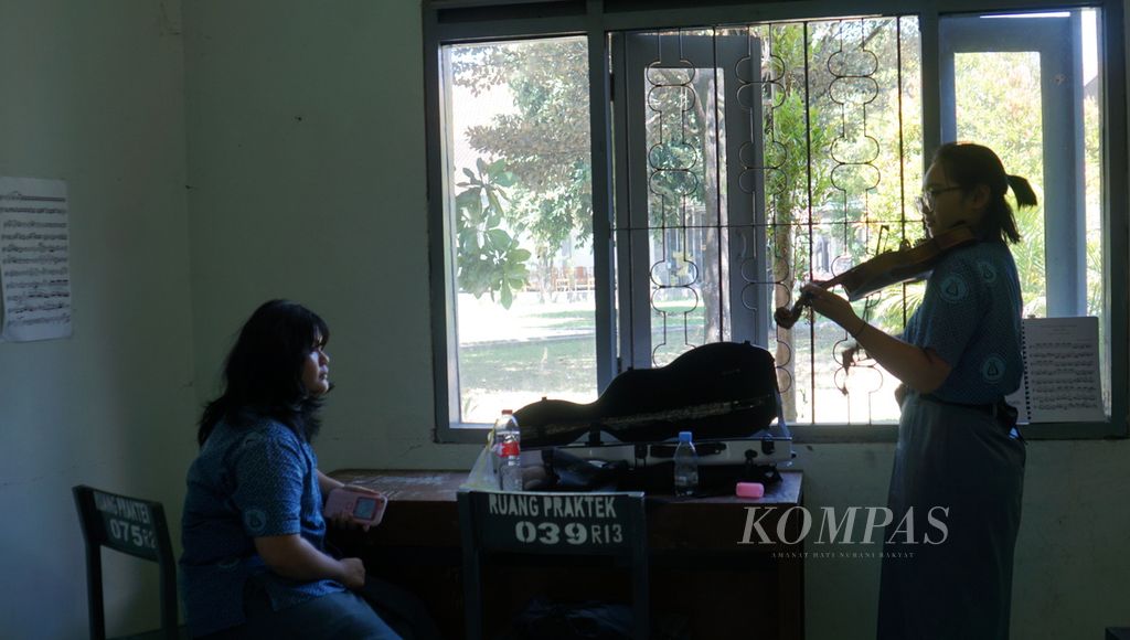 Seorang murid berlatih biola disaksikan temannya di SMK Negeri 2 Kasihan, atau SMM Yogyakarta, di Kabupaten Bantul, Daerah Istimewa Yogyakarta, Jumat (9/6/2023). 