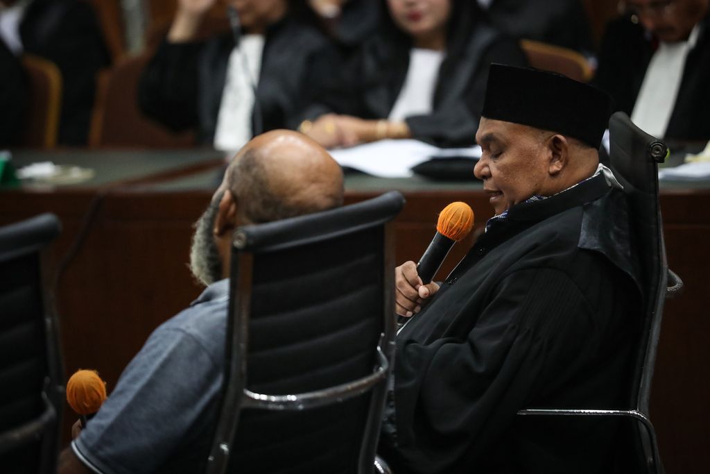 Kuasa hukum Lukas Enembe, Petrus Bala Pattyona (kanan), membacakan nota keberatan yang ditulis oleh terdakwa Lukas Enembe di Pengadilan Tindak Pidana Korupsi, Jakarta, Senin (19/6/2023).