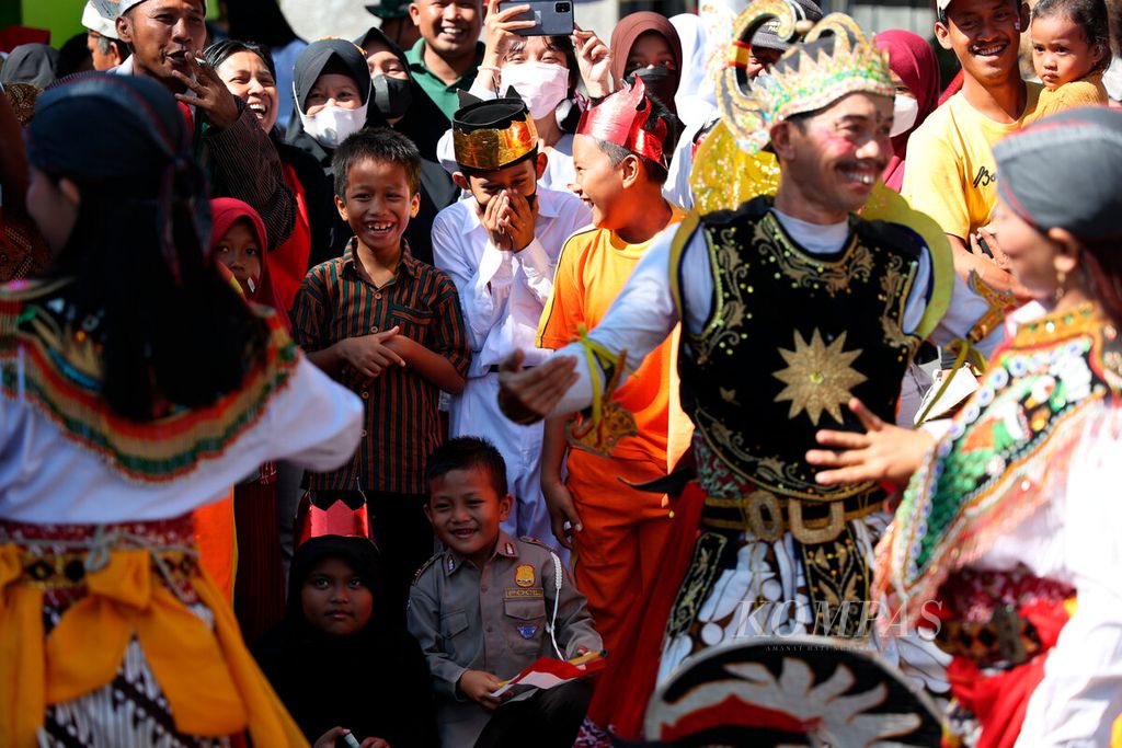 Anak-anak yang senyum dan tertawa gembira melihat pentas kesenian tradisional saat mereka mengikuti karnaval memeriahkan HUT Ke-77 RI di Kampung Waru, Kecamatan Banyumanik, Kota Semarang, Jawa Tengah, Minggu (7/8/2022). 