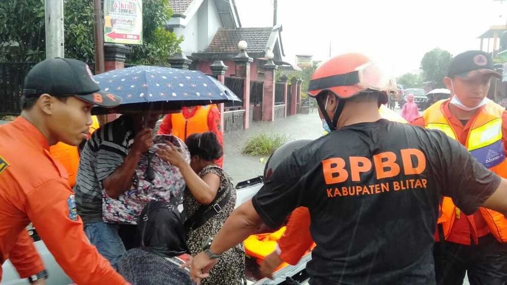 Petugas Badan Penanggulangan Bencana Daerah Kabupaten Blitar, Jawa Timur, mengevakuasi warga terdampak banjir, Senin (17/10/2022). Hujan deras sejak Minggu malam membuat debit sungai setempat meluap dan menggenangi sejumlah desa di wilayah itu.