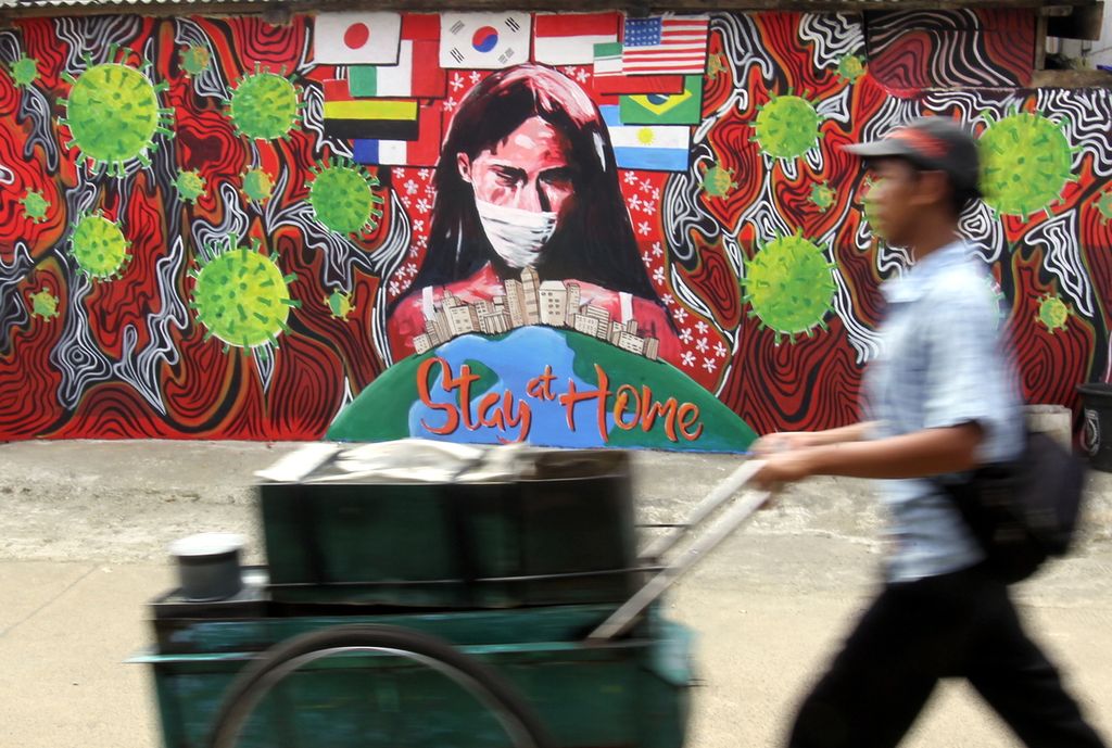 Pedagang keliling melintas di mural berkaitan dengan maraknya pandemi Covid-19 yang berada di daerah Rawageni, Depok, Jawa Barat, Kamis (9/4/2020). Mural tersebut dibuat agar masyarakat di dunia dan khususnya di Indonesia waspada terhadap pandemi Covid-19. 