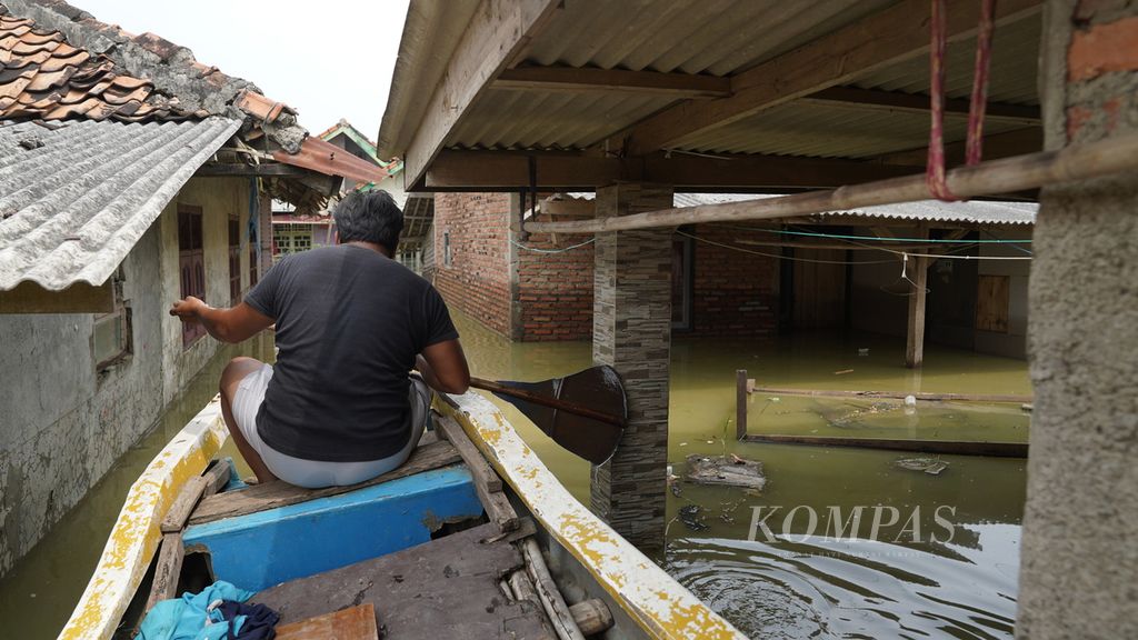 Endi mengayuh perahu melintasi hunian warga yang sudah lima hari terendam luapan Sungai Citarum dan Cibeet di Kampung Kampek, Desa Karangligar, Kecamatan Telukjambe Barat, Kabupaten Karawang, Jawa Barat, Senin (8/5/2023). 