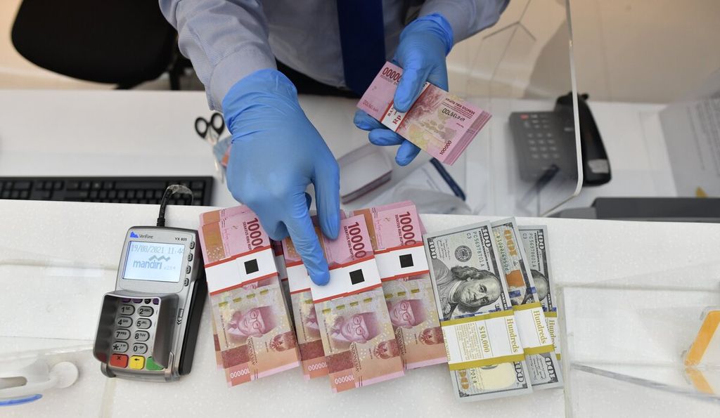 Petugas menyiapkan uang pecahan Rp 100.000 di Bank Mandiri, Jakarta, Kamis (19/8/2021).  