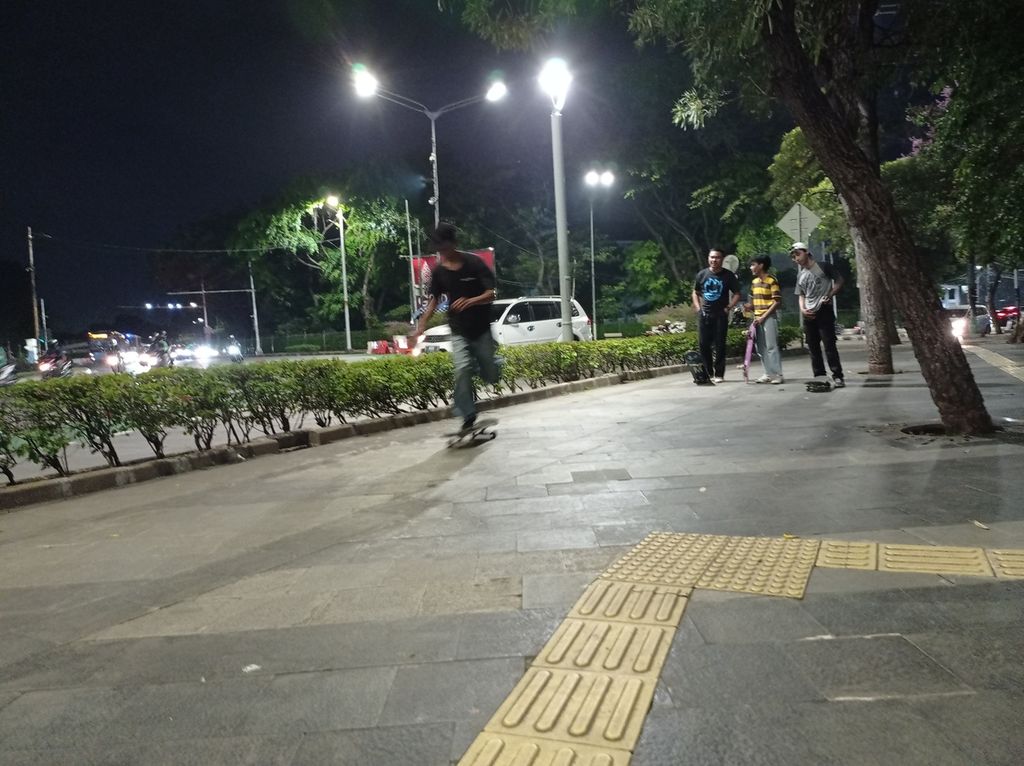 Kelompok remaja bermain <i>skateboard</i> atau papan seluncur di trotoar dekat Bundaran Senayan, Jakarta, Senin (4/4/2022).