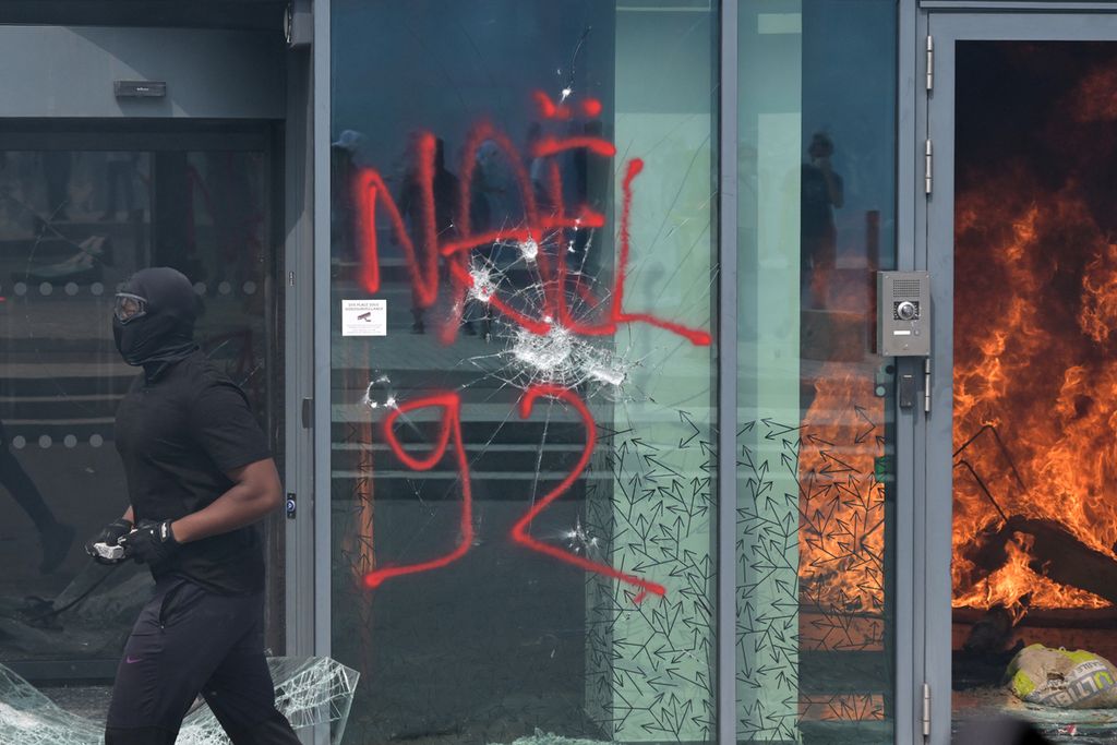 Seorang pengunjuk rasa bentrok dengan polisi selama pawai peringatan penembakan Nahel (17) oleh polisi di Nanterre, pinggiran kota Paris, pada 29 Juni 2023.