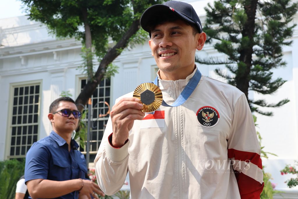 Peraih medali emas cabang panjat tebing speed putra Veddriq Leonardo menunjukkan medali yang diraihnya di Olimpiade Paris 2024. Veddriq dan rekan-rekan atlet baru bertemu Presiden Joko Widodo di halaman tengah Istana Merdeka dan Istana Negara, Jakarta, Kamis (15/8/2024).