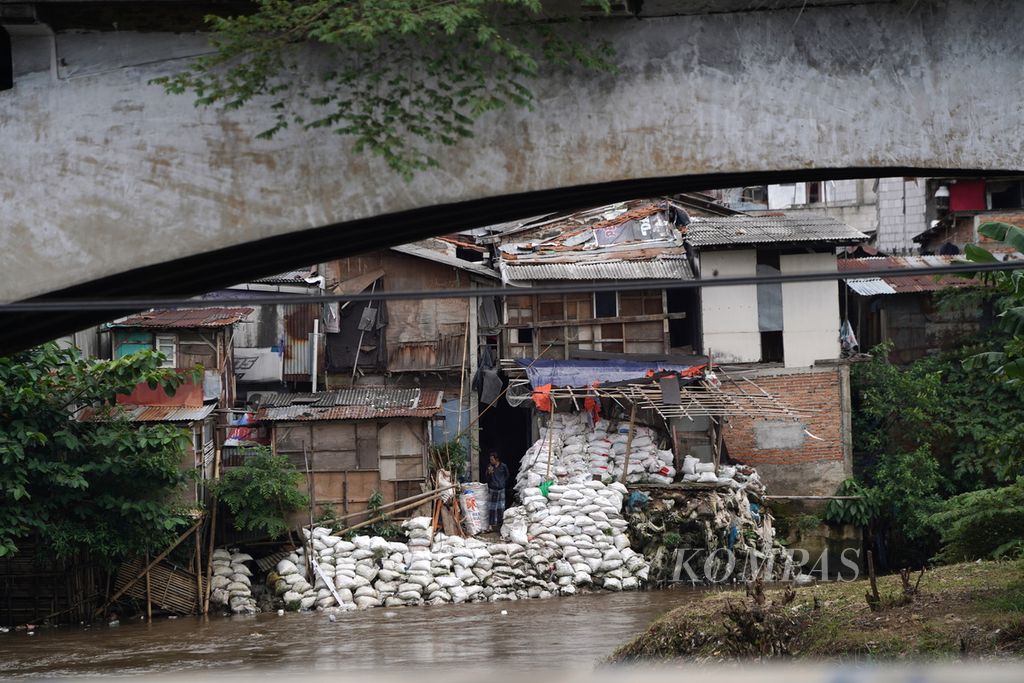 Residents are checking the condition of the Ciliwung River around their homes, which have been protected with sandbags in Kampung Melayu, Jatinegara, East Jakarta, on Monday (11/3/2024).