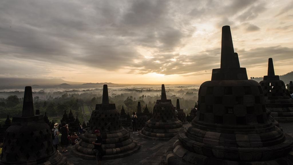Wisatawan menikmati suasana matahari terbit di kawasan Taman Wisata Candi Borobudur, Magelang, Jawa Tengah, Sabtu (15/12/2018). Wisata alam menyaksikan matahari terbit dari Candi Borobudur menjadi salah satu tujuan favorit wisatawan lokal dan mancanegara.
