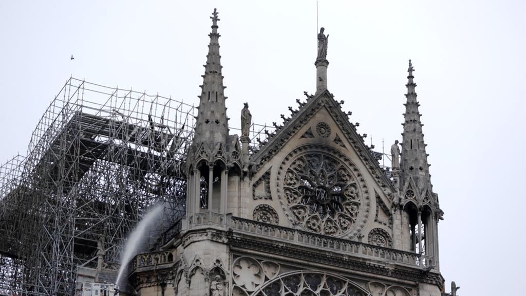 Petugas pemadam kebakaran menyemprotkan air untuk memadamkan api yang membakar Katedral Notre Dame di Paris, Perancis, Selasa (16/4/2019) pagi waktu setempat. Setelah bekerja berjam-jam, petugas pemadam kebakaran dapat mengendalikan api yang menghancurkan Katedral Notre Dame.