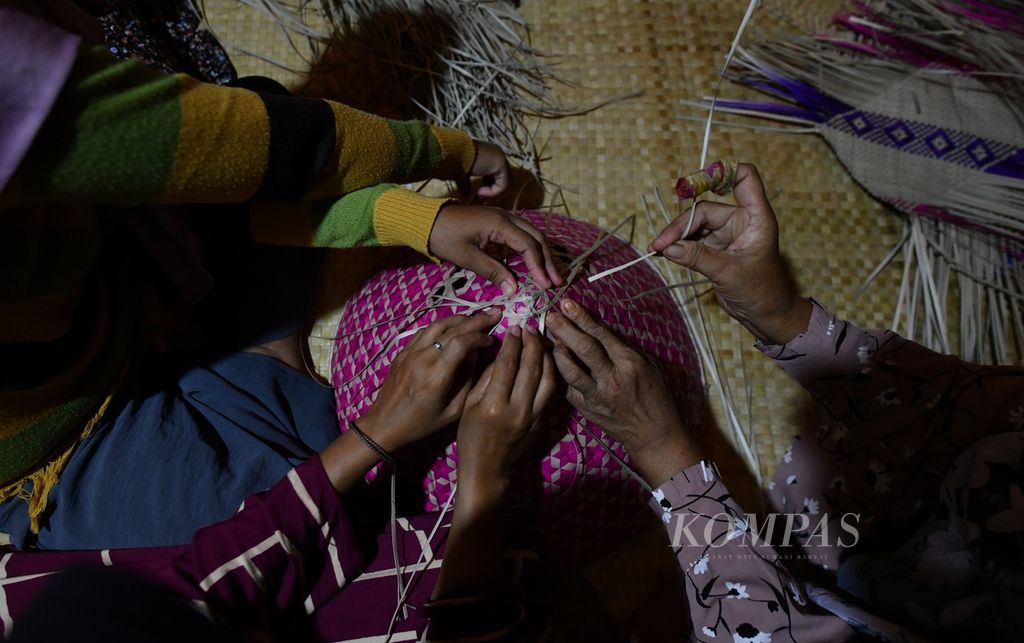 Sejumlah perempuan menyelesaikan pembuatan kerajinan berbahan anyaman pandan di Desa Danau Lamo, Kecamatan Maro Sebo, Muaro Jambi, Jambi, Selasa (9/7/2024). Kerajinan yang dibuat antara lain tudung saji, tikar, kembut atau tempat menyimpan bumbu dapur hingga lapik bayi.  