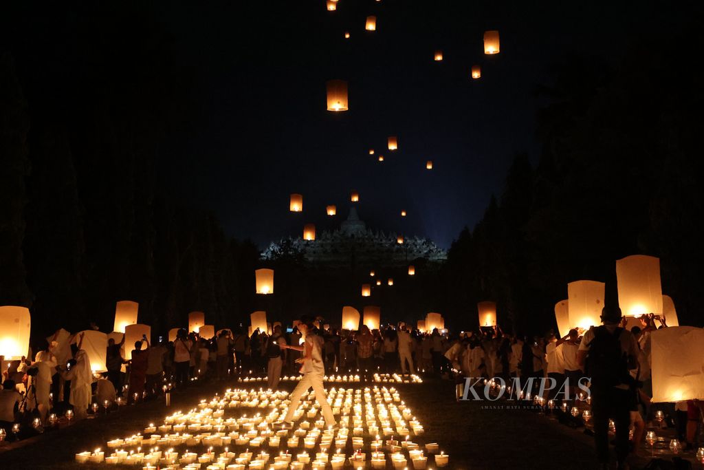 Umat Buddha dan wisatawan menerbangkan lampion dalam acara perayaan Waisak 2566 BE di kompleks Candi Borobudur, Magelang, Jawa Tengah, Senin (16/5/2022). Kegiatan penerbangan lampion merupakan salah satu agenda yang dinanti saat perayaan Waisak di tempat itu. Lampion yang diterbangkan antara lain menjadi simbol penyampaian doa dan harapan.
