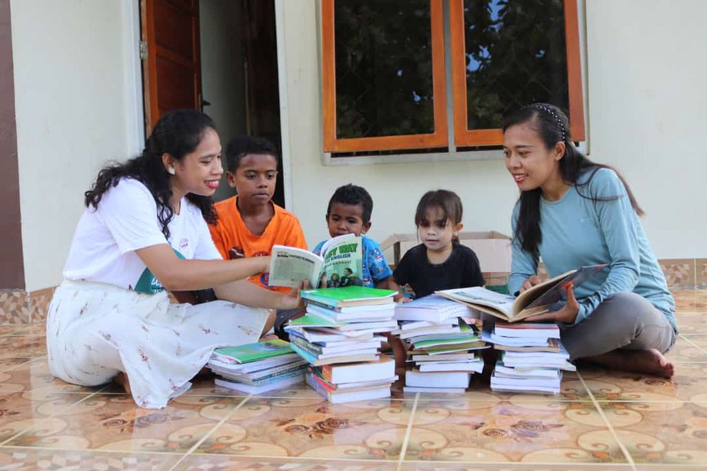 Beatrix Yunarti Manehat (left) with a reading garden companion sorting out reading books sent by donors, at Yunarti's parents' house in Kefamenanu, East Nusa Tenggara. 