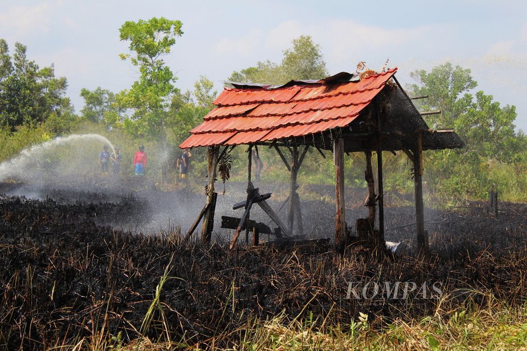 Tim gabungan pemadam kebakaran hutan dan lahan memadamkan tanah kavling dan sebuah pondok yang hangus terbakar di Jalan Kalibata, Kota Palangkaraya, Kalimantan Tengah, Senin (14/8/2023). 