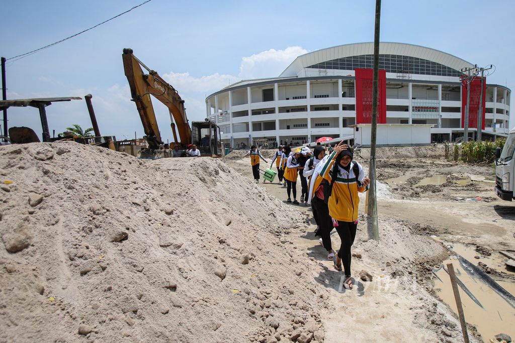 Atlet voli putri Kalimantan Timur harus berbagi jalan dengan tumpukan pasir yang digunakan untuk meratakan jalan menuju GOR Bola Voli Indoor Sumut Sport Center, Deli Serdang, Sumatera Utara, Rabu (11/9/2024).