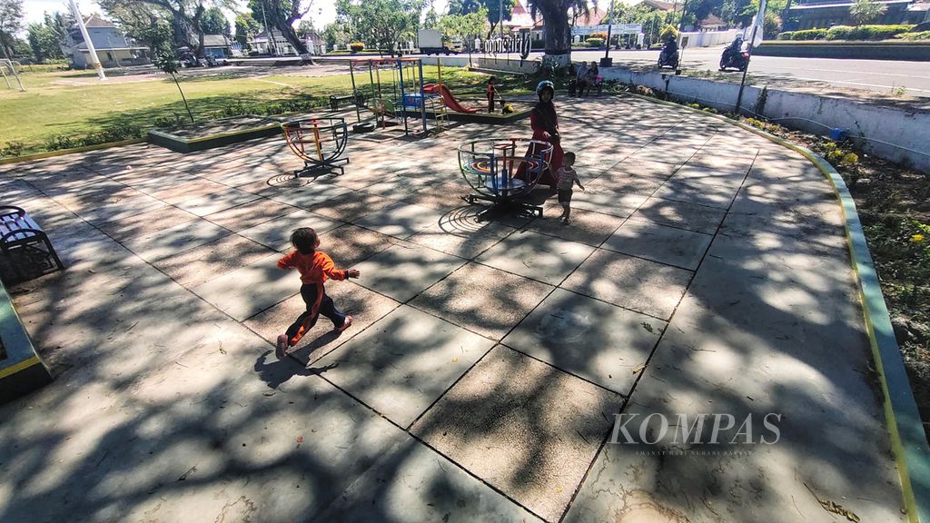 Anak-anak bermain sembari berteduh menjelang tengah hari di Lapangan Trihanggo, Bantul, DIY, Jumat (9/6/2023). 