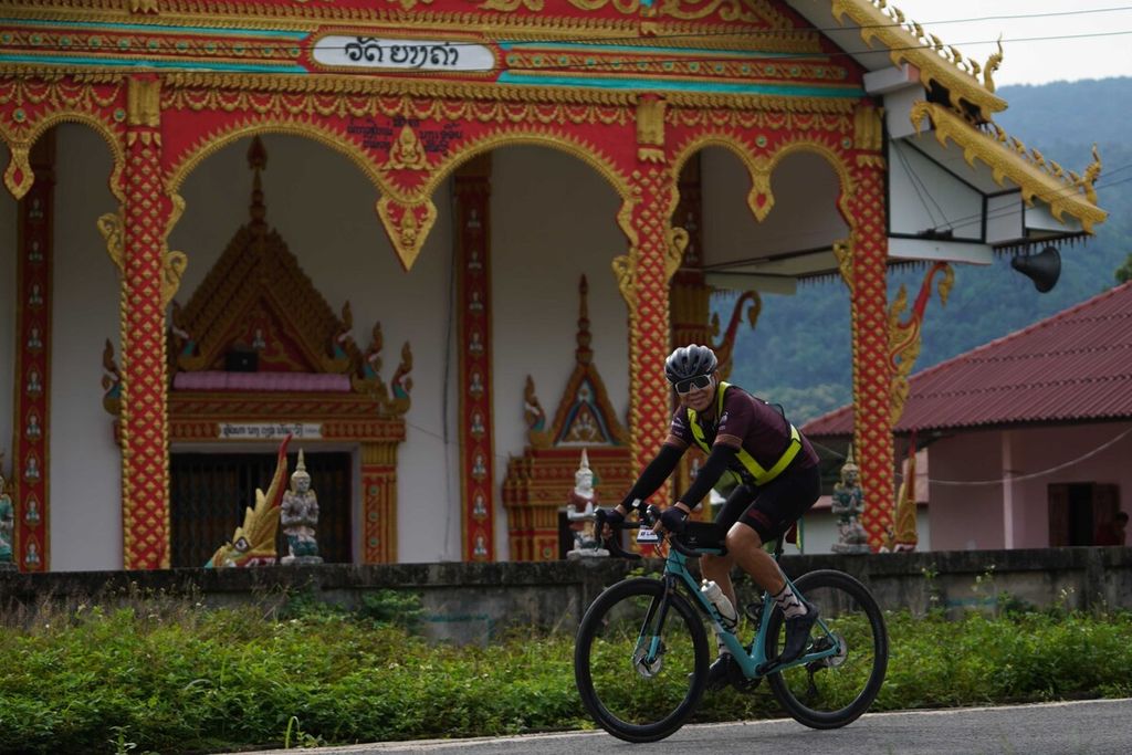 Pesepeda asal Indonesia, Royke Lumowa, tengah melaju di Laos.
