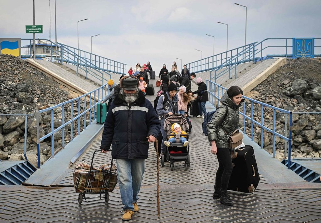 Pengungsi Ukraina berjalan beriring memasuki kapal ferry, di pelabuhan Isaccea-Orlivka untuk menyeberangi Sungai Danube di perbatasan Ukraina-Romania pada Jumat (25/3/2022).