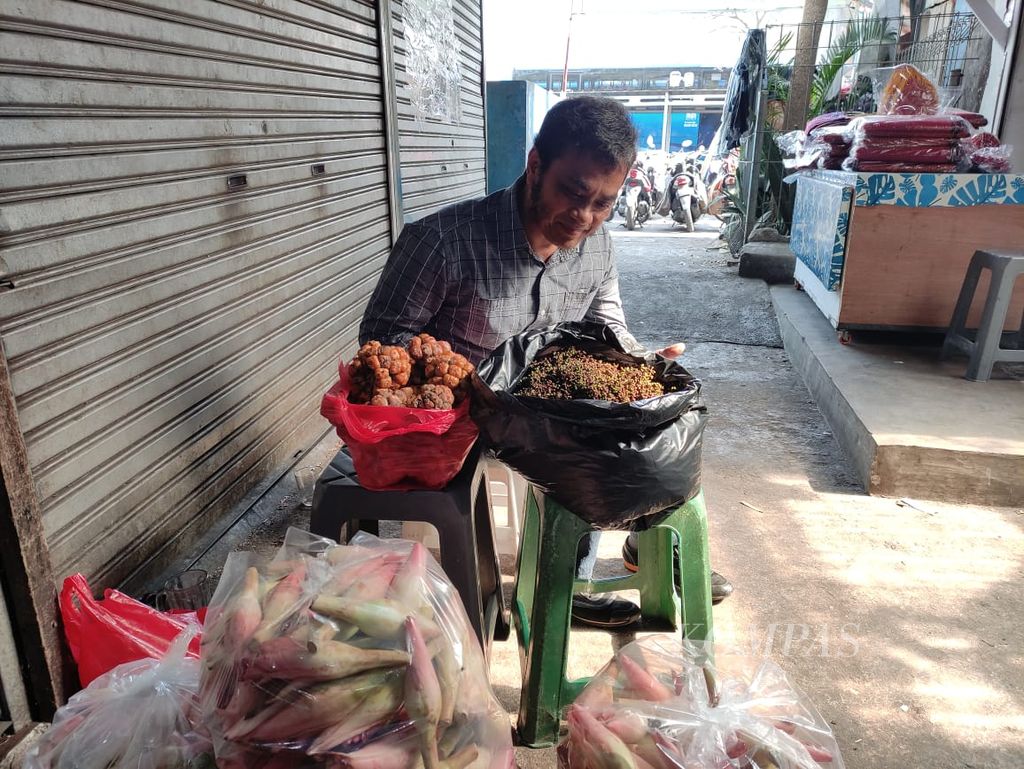 Cosmos Silalahi mengecek bumbu-bumbu yang dijualnya di Pasar Senen, Jakarta, Jumat (29/9/2023).