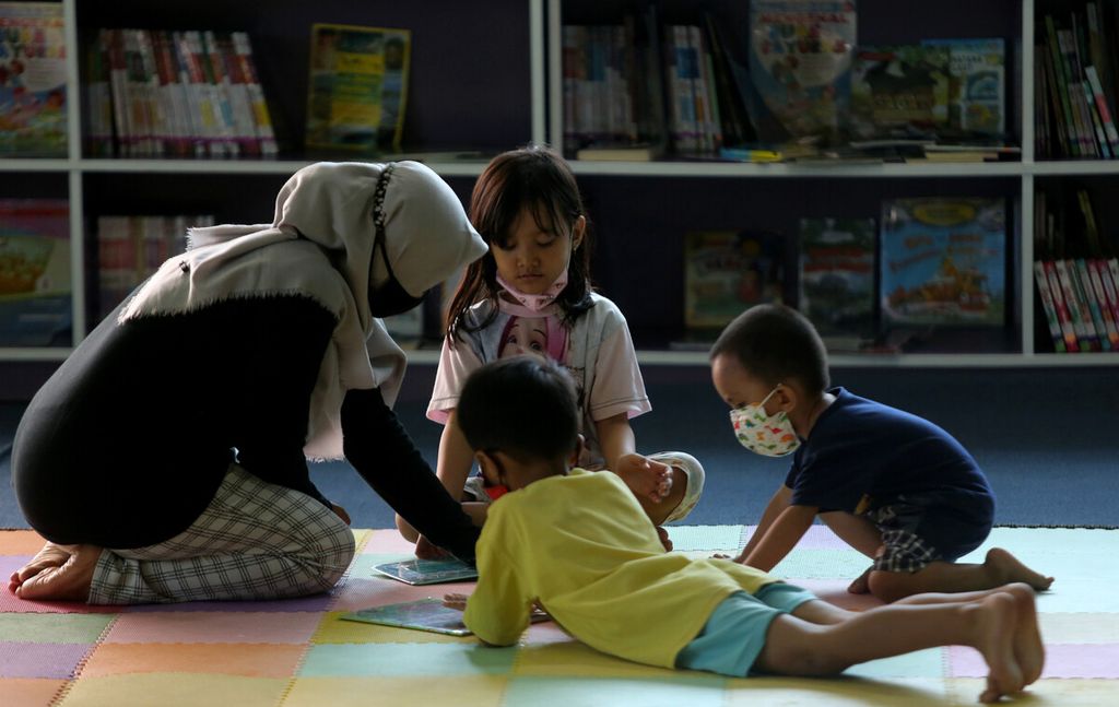 Orangtua mendampingi anak-anak membaca buku di Perpustakaan Umum dan Depo Arsip di Rawa Bunga, Jatinegara, Jakarta Timur, Selasa (28/12/2021). Sebagian anak-anak memilih untuk memanfaatkan waktu libur sekolah dengan mengunjungi perpustakaan umum. 