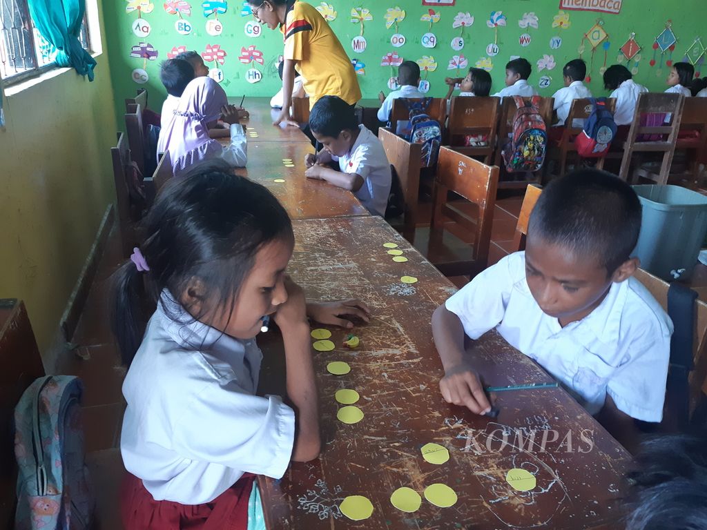 Siswa kelas I SD Negeri Waikelo di Kabupaten Sumba Barat Daya, Nusa Tenggara Timur, belajar menuliskan bagian tanaman di kertas usia panen kangkung di kebun pangan sekolah, Selasa (31/5/2022).