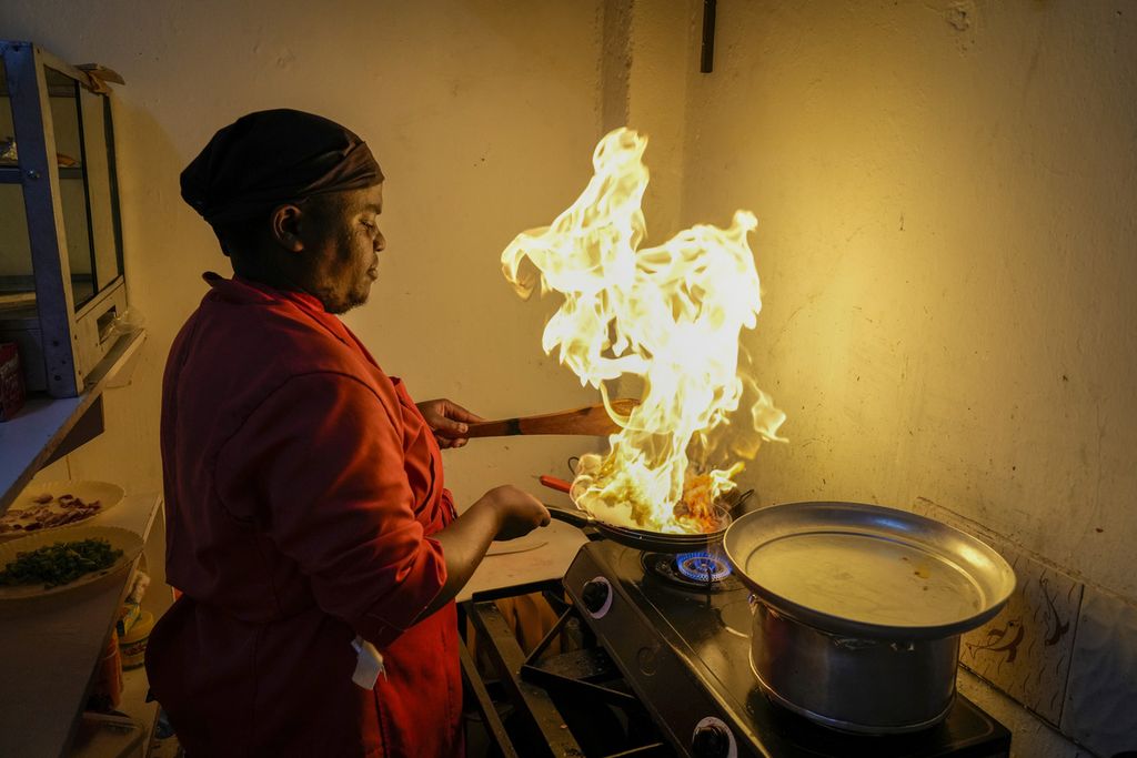 Foto yang diambil pada 17 April 2023 memperliihatkan Mark Kioko, juru masak dan pemilik restoran di Kitengela, Nairobi, Kenya, tengah memasak di dapur restoran miliknya. Menurut Kioko, dirinya harus memutar otak karena harga bahan makanan terus naik seiring kenaikan harga energi. 