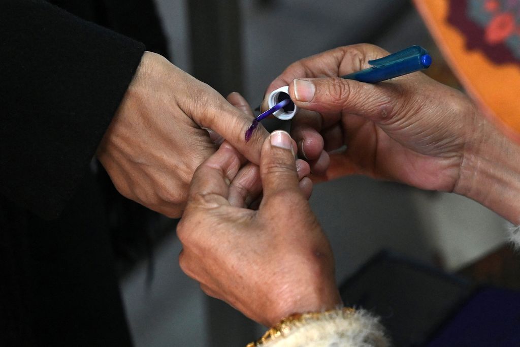 Petugas menandai ibu jari seorang perempuan setelah dia memberikan suaranya di tempat pemungutan suara pada pemilu nasional Pakistan di Lahore, Kamis (8/2/2024). 