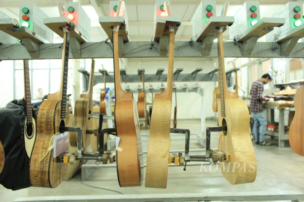 Gitar di PT Genta Trikarya dalam proses perekatan untuk hasil yang terbaik, Senin (6/3/2023).