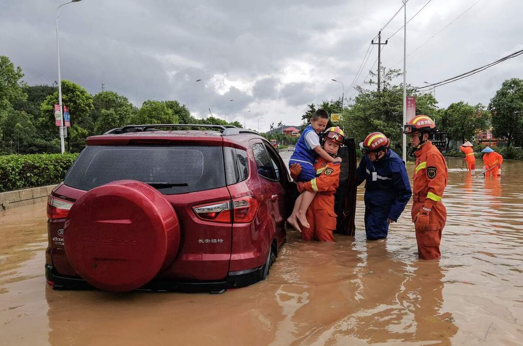Tim penyelamat tengah mengevakuasi warga dari sebuah mobil yang terendam banjir akibat terjangan topan Doksuri di Quanzhou, Provinsi Fujian, China pada Jumat (28/7/2023).