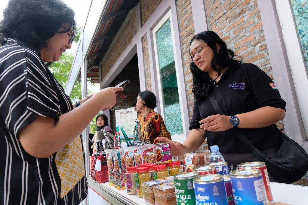 Seorang warga membeli produk usaha mikro, kecil, dan menengah (UMKM) para perempuan di Desa Sinduharjo, Kecamatan Ngaglik, Kabupaten Sleman, DI Yogyakarta pada Rabu (5/7/2023). 