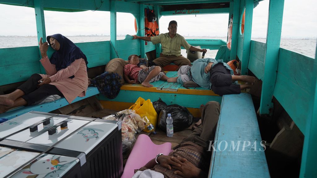 Passengers sleep on the Sinar Ada motor boat heading Cilincing-Muaragembong in Jakarta Bay, on Wednesday (26/10/2022).